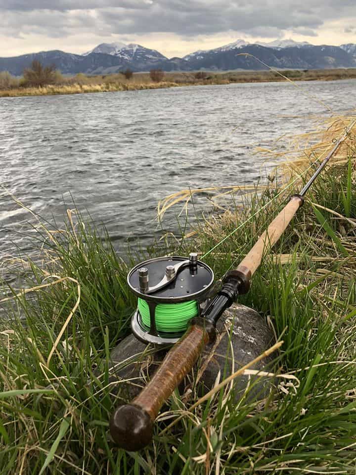 meiser rod and reel leaning on ground in front of river